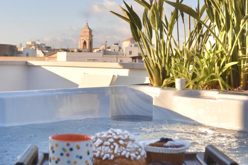 Colazione in terrazza con vista sulla città e jacuzzi.