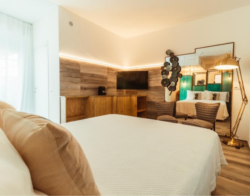 Camera moderna con letto matrimoniale, TV a schermo piatto e arredamento elegante.